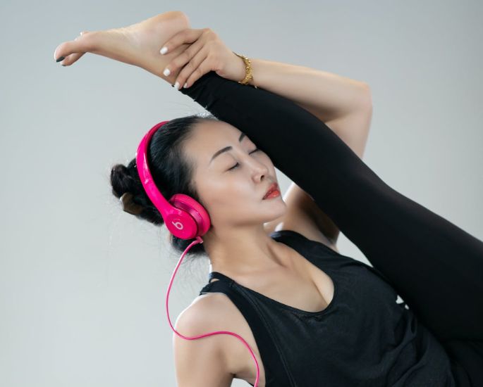 frau hört podcast beim yoga